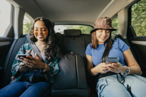 Friends sit in the backseat of a car after calling for Taxis Peoria IL trust