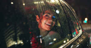 Taxis Pekin IL, Smile, woman and window of car at night for travel, sightseeing city and tourism holiday. Happy, passenger and thinking with phone in vehicle, rain weather and urban view for evening journey of trip